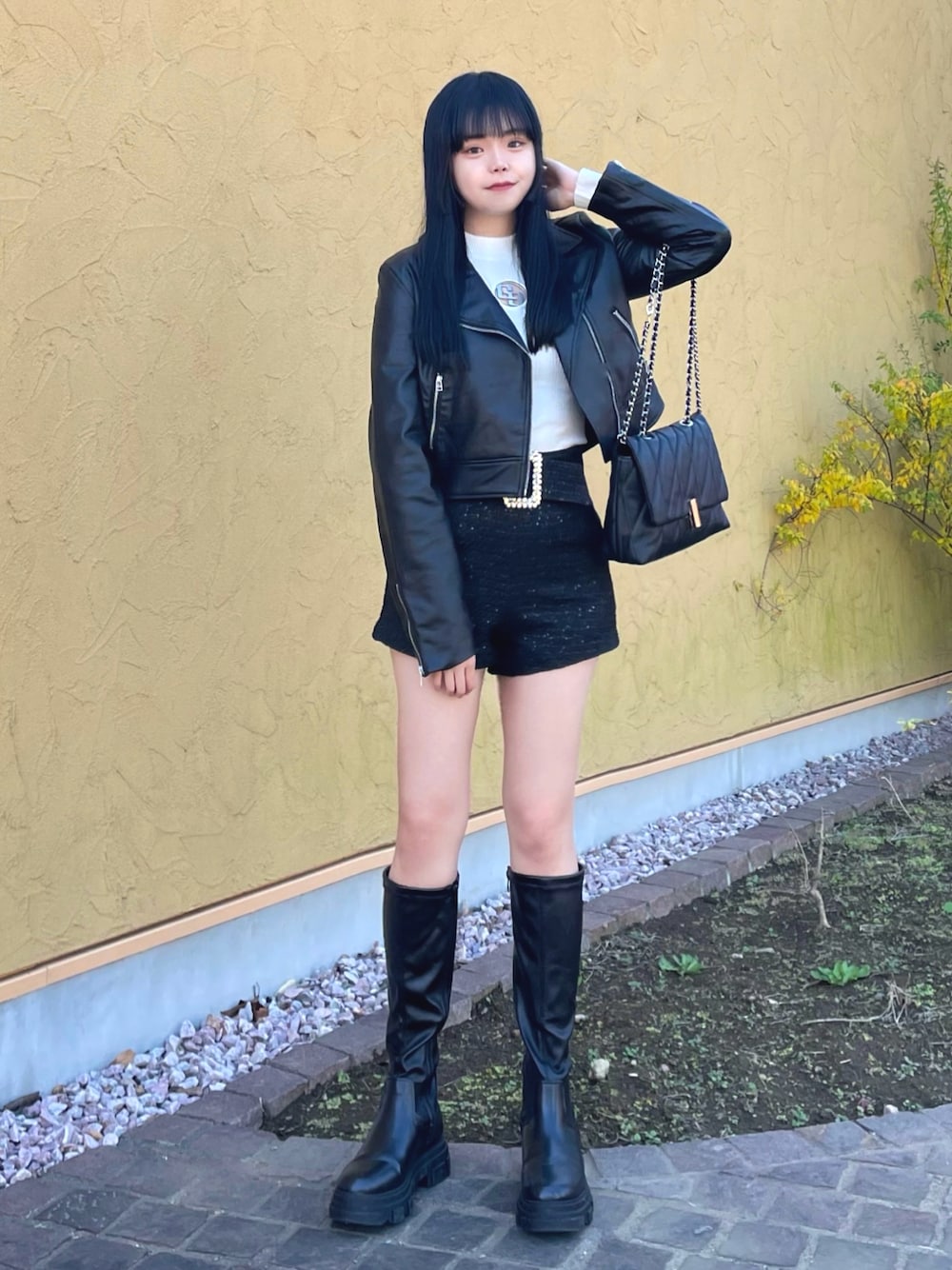 ブラック系のライダースジャケット、ホワイト系のニット/セーター、ブラック系のその他パンツを着用したレディースの冬コーディネートの1枚目の写真