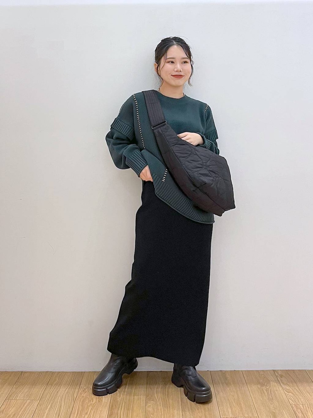 ブラック系のブーツ、ブラック系のショルダーバッグ、グリーン系のTシャツ/カットソーを着用したレディースの秋コーディネートの1枚目の写真