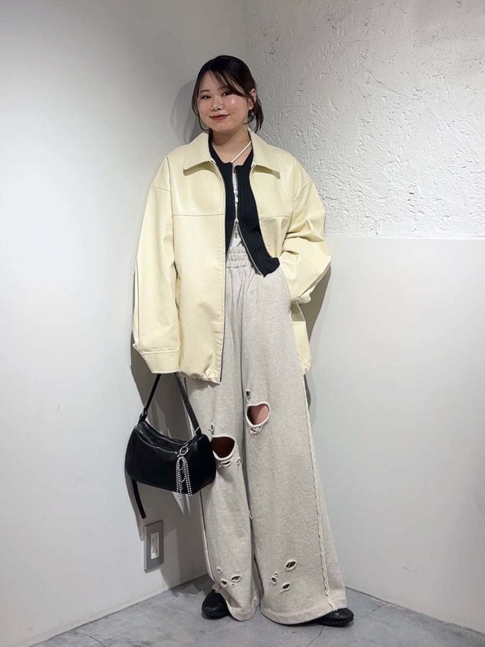 ブラック系のカーディガン/ボレロ、シルバー系のトートバッグ、ブラック系のスニーカーを着用したレディースの春コーディネートの1枚目の写真