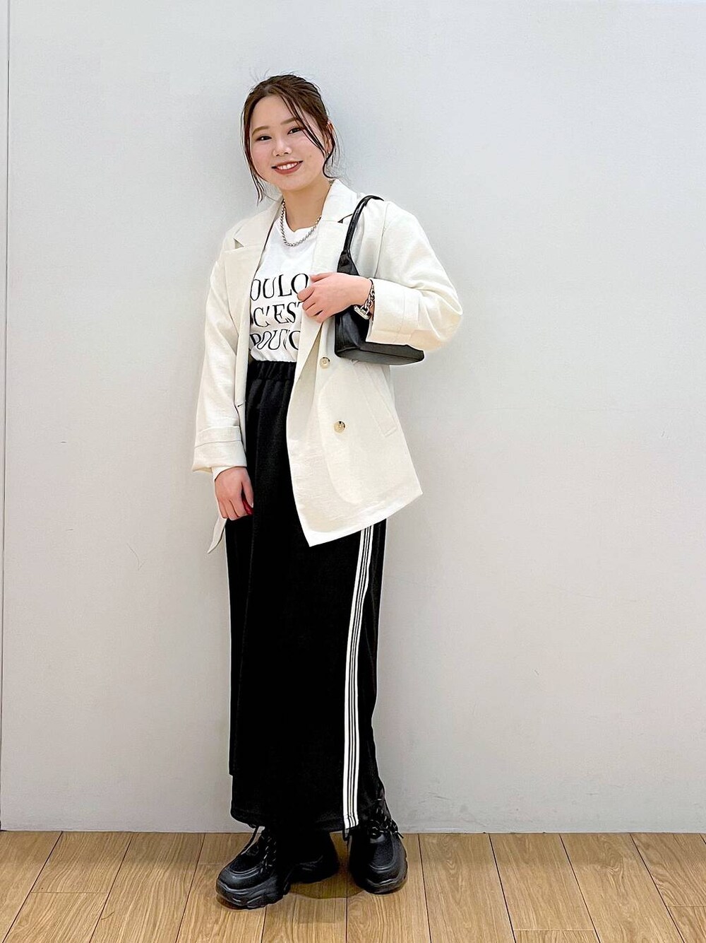 ホワイト系のテーラードジャケット、ホワイト系のTシャツ/カットソー、ブラック系のスニーカーを着用したレディースの春コーディネートの1枚目の写真