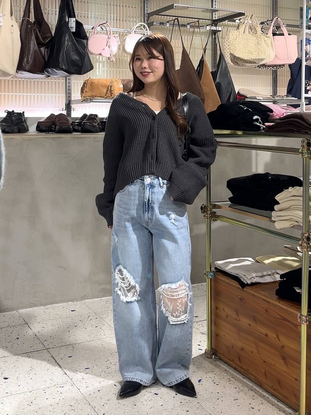 ホワイト系のキャミソール、ブラック系のパンプス、ブルー系のデニムパンツを着用したレディースの冬コーディネートの1枚目の写真