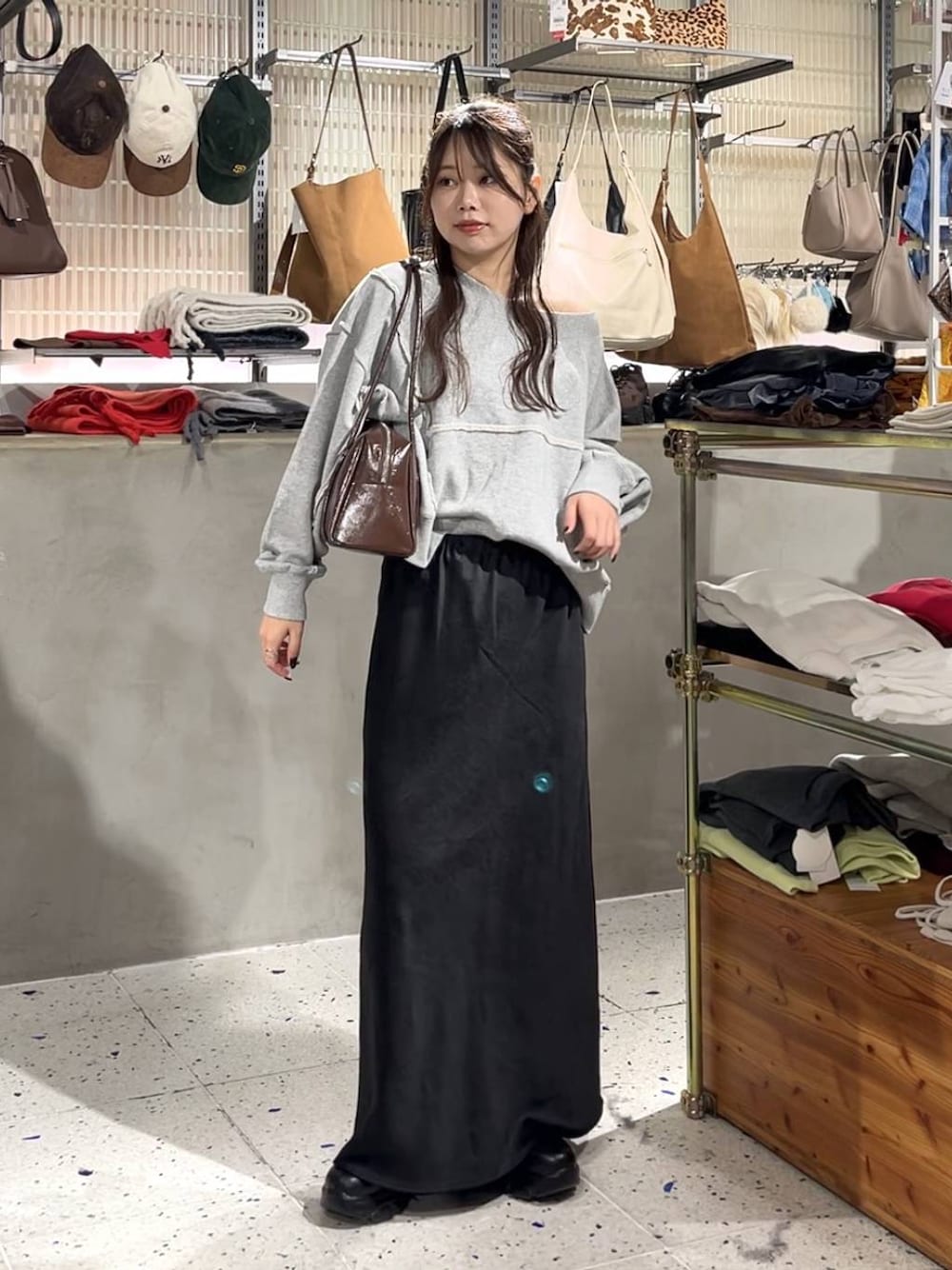 ブラック系のブーツ、グレー系のスウェット、ブラック系のスカートを着用したレディースの秋コーディネートの1枚目の写真