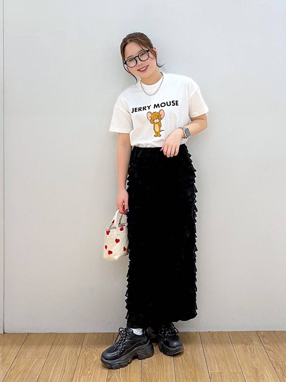 ブラック系のスカート、ホワイト系のTシャツ/カットソー、レッド系のショルダーバッグを着用したレディースの春コーディネートの1枚目の写真