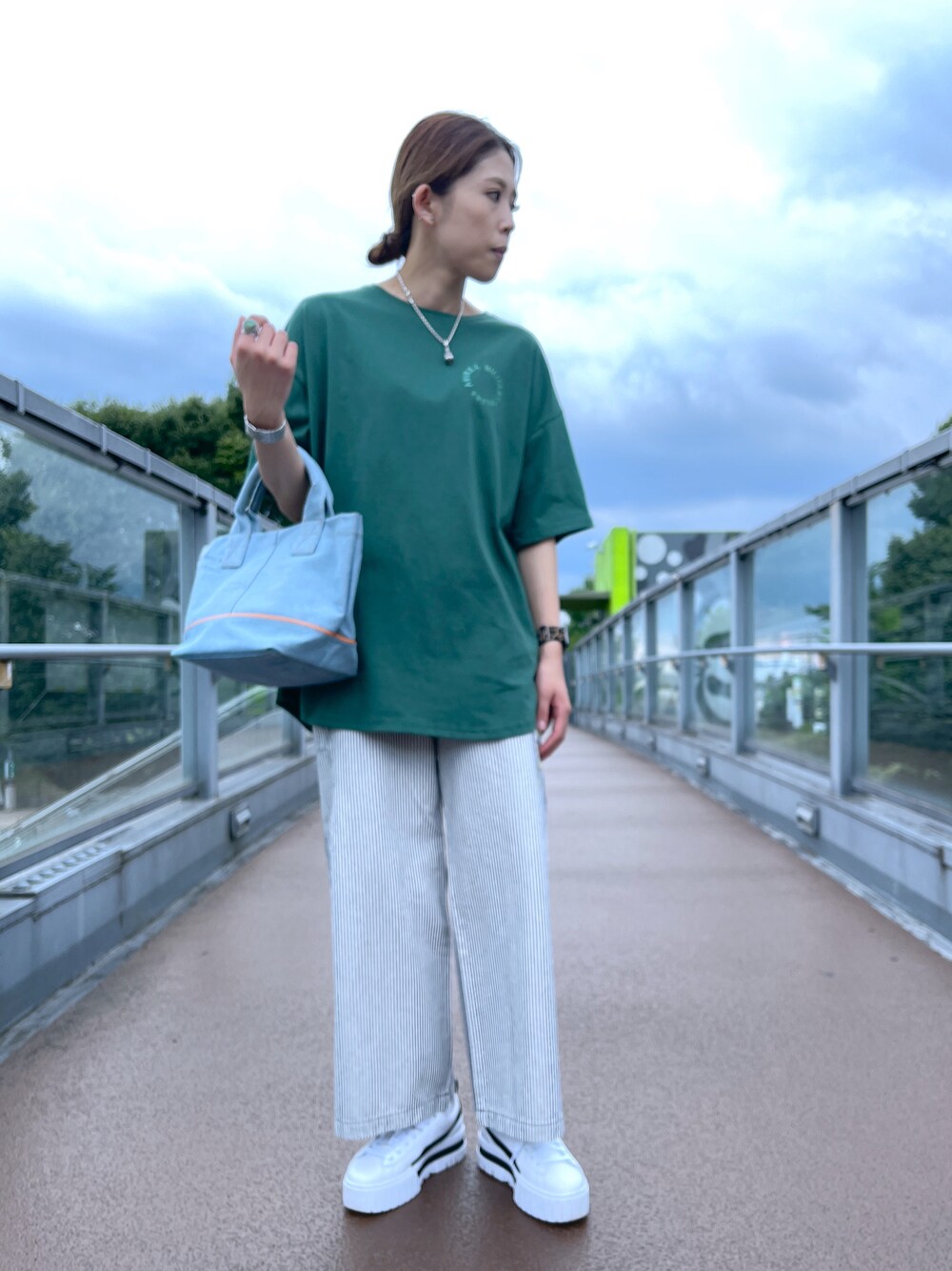 その他のトートバッグ、グリーン系のチュニック、その他のデニムパンツを着用したレディースの夏コーディネートの1枚目の写真