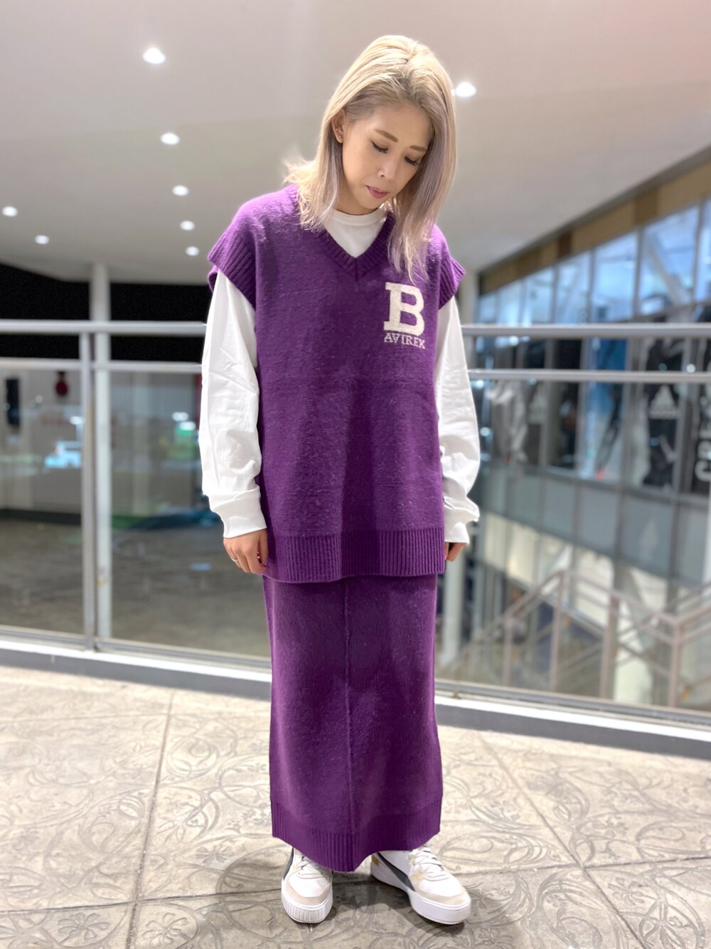 パープル系のベスト、ホワイト系のTシャツ/カットソー、パープル系のスカートを着用したレディースの秋コーディネートの1枚目の写真