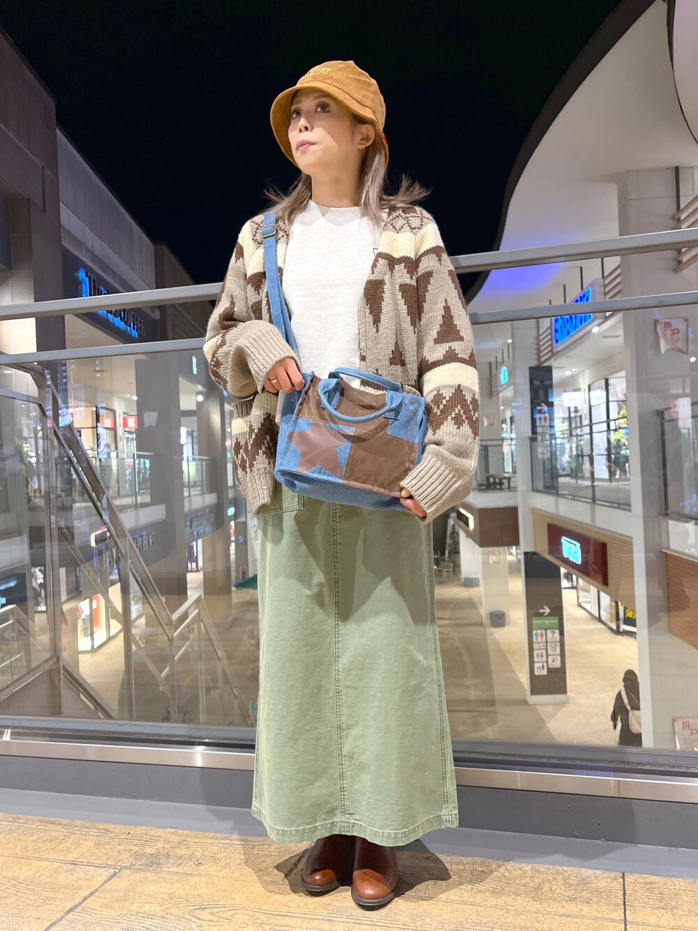 ベージュ系のスウェット、ブルー系のトートバッグ、ブラウン系のカーディガン/ボレロを着用したレディースの冬コーディネートの1枚目の写真