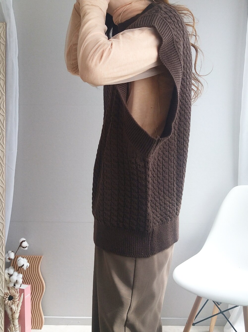 ブラウン系のベスト、イエロー系のショルダーバッグ、グレー系のスニーカーを着用したレディースの春コーディネートの2枚目の写真