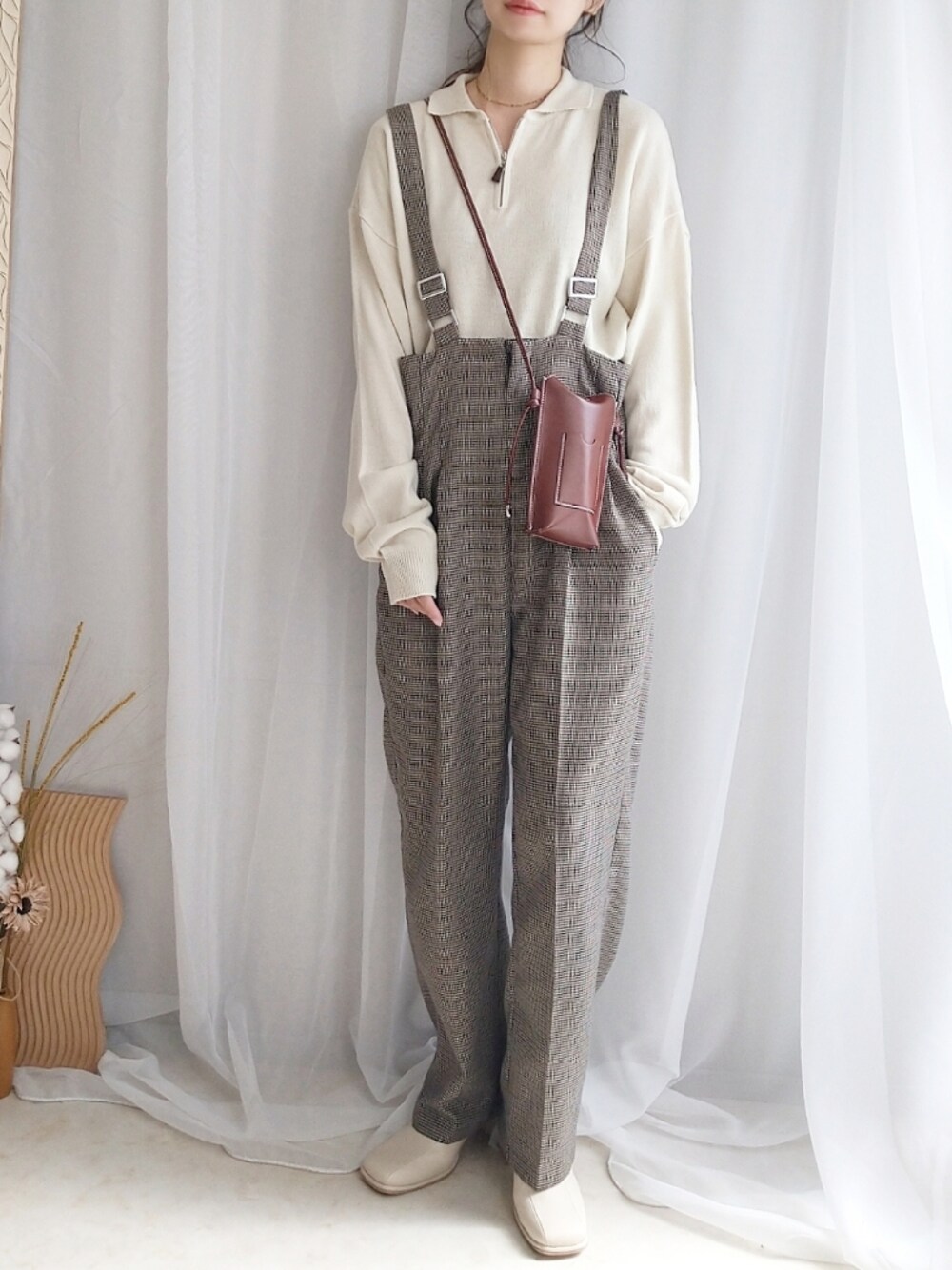 ベージュ系のニット/セーター、ブラウン系のショルダーバッグ、その他のサロペット/オーバーオールを着用したレディースの秋コーディネートの1枚目の写真