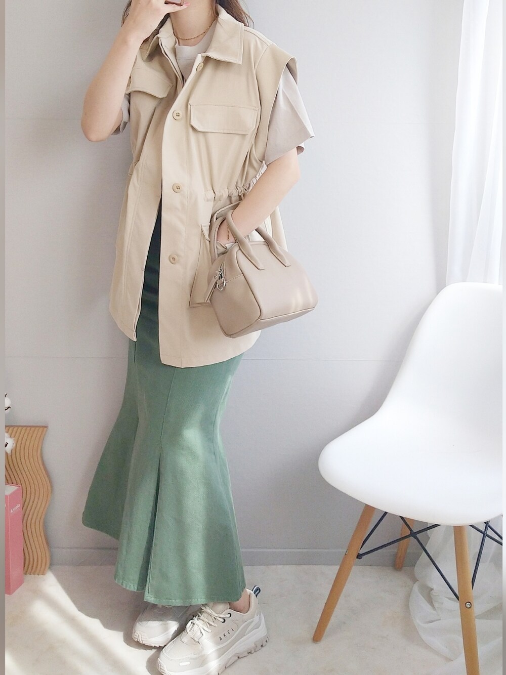 ベージュ系のミリタリージャケット、ブラウン系のTシャツ/カットソー、ベージュ系のボストンバッグを着用したレディースの春コーディネートの2枚目の写真