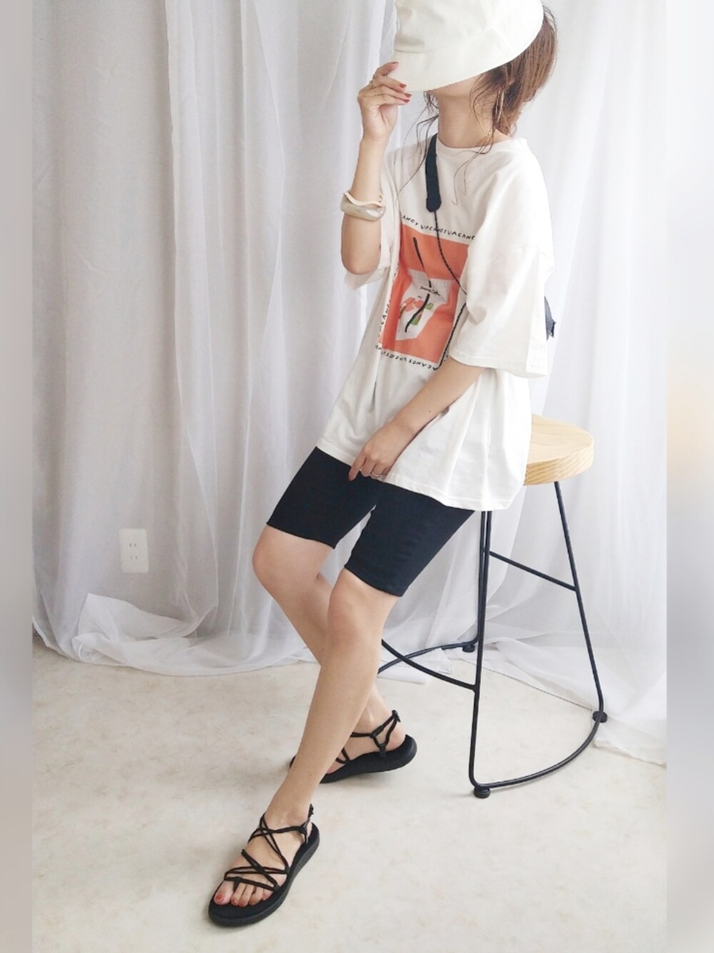 オレンジ系のTシャツ/カットソー、ブラック系のボディバッグ/ウエストポーチ、ブラック系のサンダルを着用したレディースの夏コーディネートの1枚目の写真