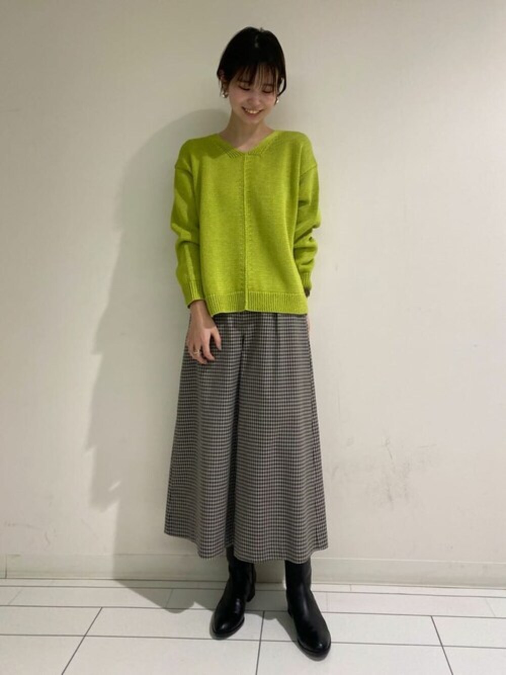 グリーン系のニット/セーター、ベージュ系のその他パンツ、ブラック系のブーツを着用したレディースの冬コーディネートの1枚目の写真