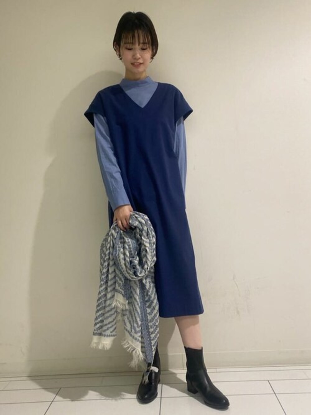 ブルー系のシャツ/ブラウス、ブルー系のワンピース、ブラック系のブーツを着用したレディースの春コーディネートの1枚目の写真