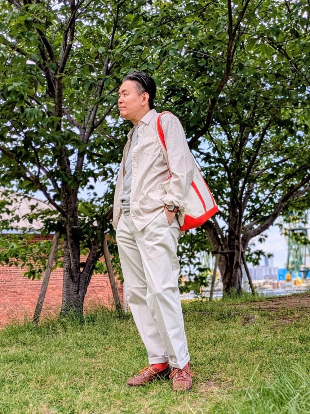 ブラウン系のチノパンツ、グレー系のTシャツ/カットソー、ブルー系のシャツ/ブラウスを着用したメンズの春コーディネートの1枚目の写真