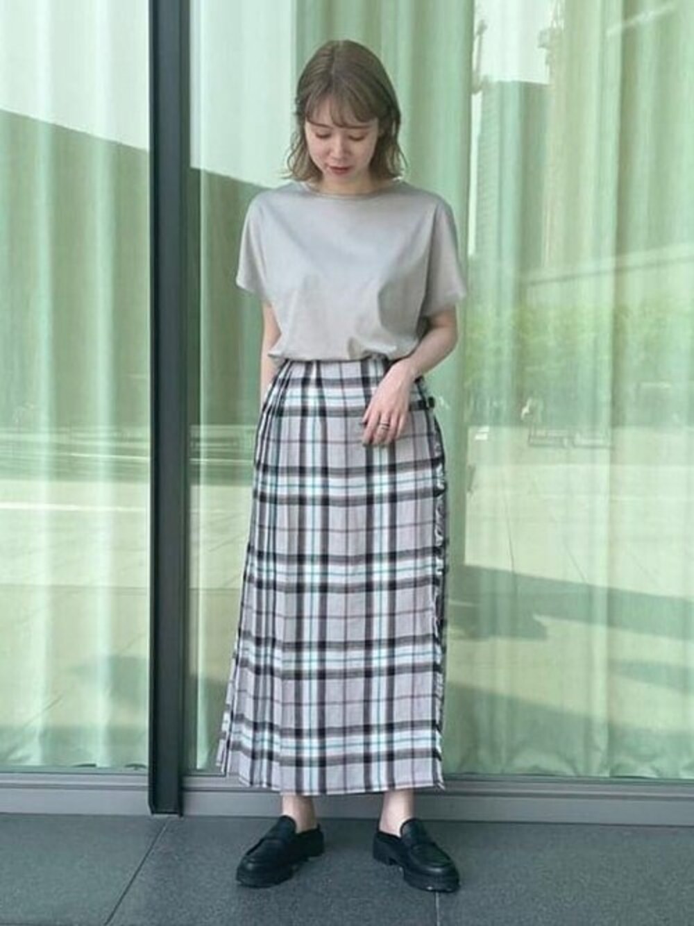 グレー系のTシャツ/カットソー、ブラック系のスカート、ブラック系のサンダルを着用したレディースの夏コーディネートの1枚目の写真