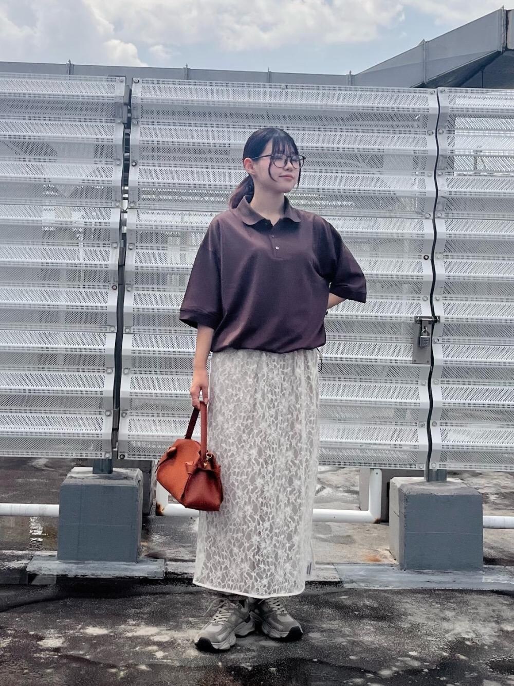 ベージュ系のスニーカー、ベージュ系のその他パンツ、ブラウン系のポロシャツを着用したレディースの夏コーディネートの1枚目の写真