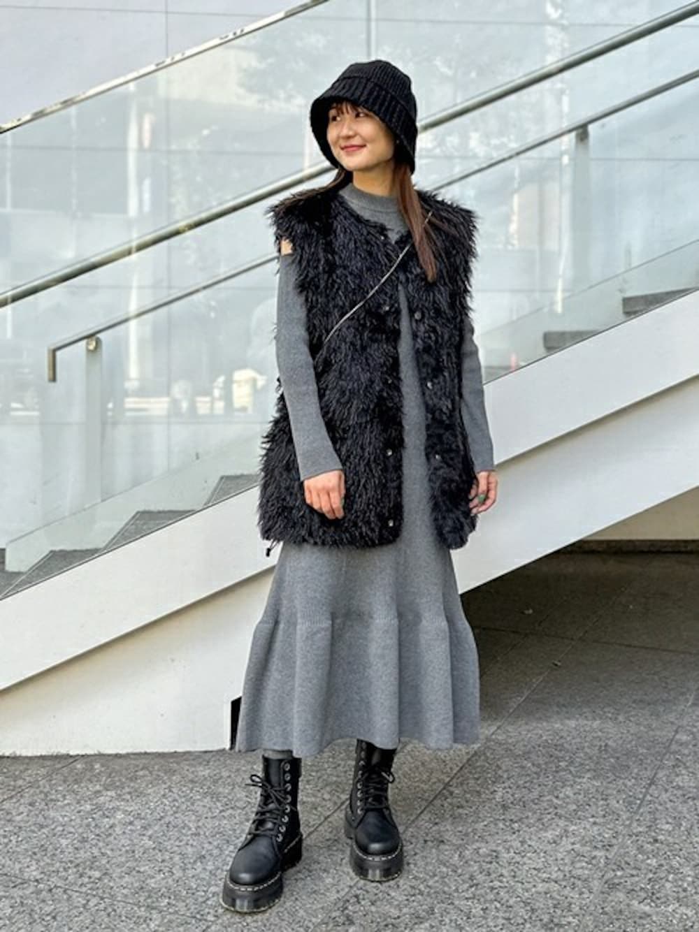 ブラック系のその他アウター、グレー系のワンピース、ブラック系のブーツを着用したレディースの秋コーディネートの1枚目の写真