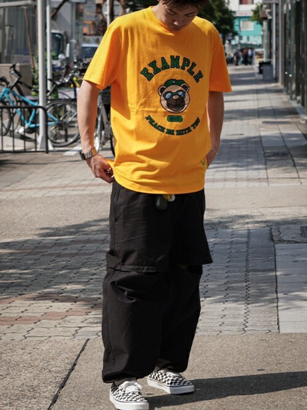 「VANS、プリントT、夏コーデ、シンプルスタイル、チェッカー、2wayパンツ、example、MFCSTORE、MFC STORE、BBBEAR」｜「EXAMPLEのEXAMPLE COLLEGE BBBEAR S/S TEE（Tシャツ/カットソー、オレンジ系）」を使った、MFC STORE 名古屋さん（メンズ・170cm）の夏コーディネートの1枚目の写真