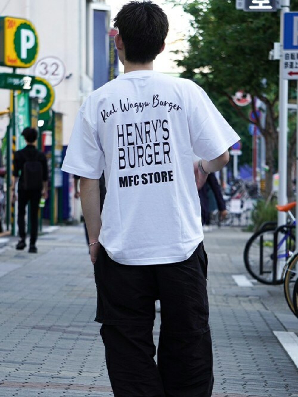 「ロゴT、コラボレーション、夏コーデ、シンプルスタイル、白Tシャツ、ストリートコーデ、2wayパンツ、MFCSTORE、MFC STORE、HENRY’S BURGER」｜「MFC STOREのHENRY’S BURGER x MFC STORE S/S TEE No.1（Tシャツ/カットソー、ホワイト系）」を使った、MFC STORE 名古屋さん（メンズ・170cm）の夏コーディネートの1枚目の写真