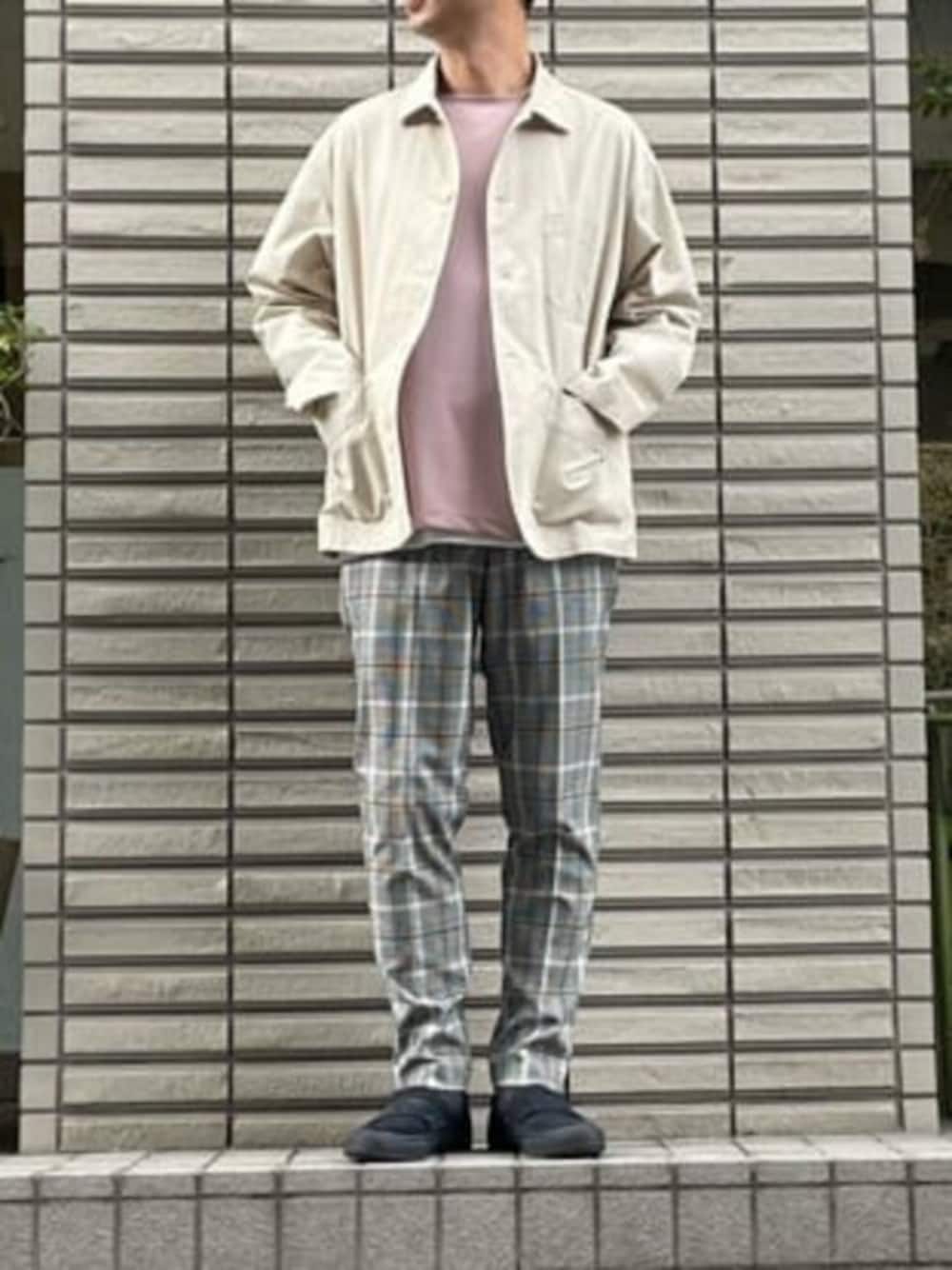 ベージュ系のカバーオール、ピンク系のアンサンブル、ホワイト系のスラックスを着用したメンズの春コーディネートの1枚目の写真