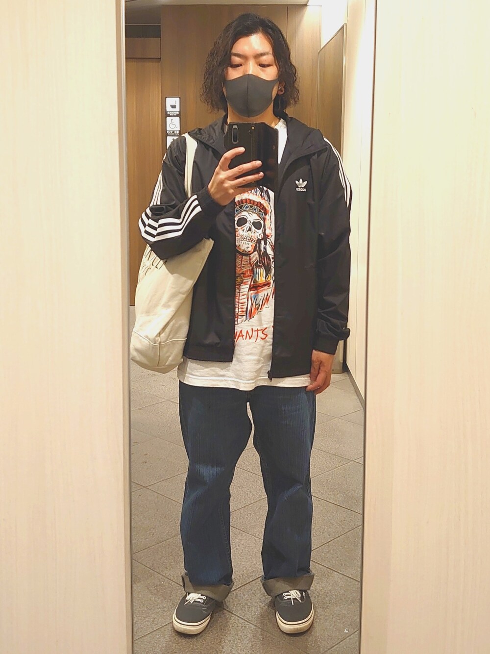 ブルー系のデニムパンツ、ブラック系のスニーカー、ホワイト系のTシャツ/カットソーを着用したメンズの春コーディネートの1枚目の写真