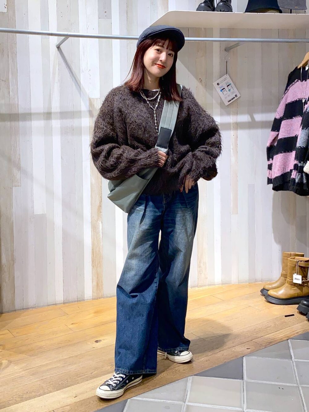 グリーン系のボディバッグ/ウエストポーチ、ブルー系のデニムパンツ、ブラウン系のニット/セーターを着用したレディースの秋コーディネートの1枚目の写真