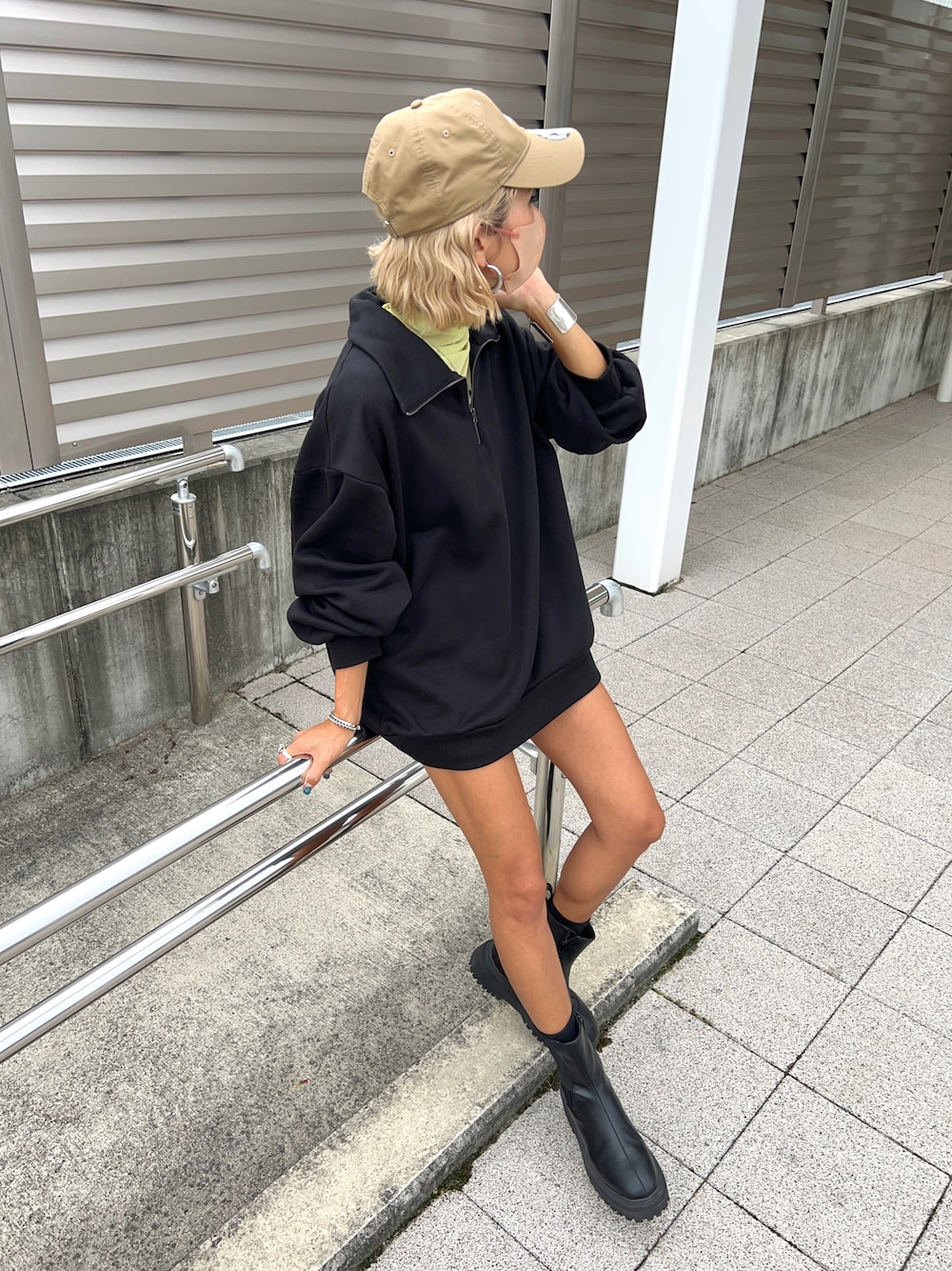 ブラック系のスウェット、グリーン系のTシャツ/カットソー、ブラック系のブーツを着用したレディースの秋コーディネートの1枚目の写真