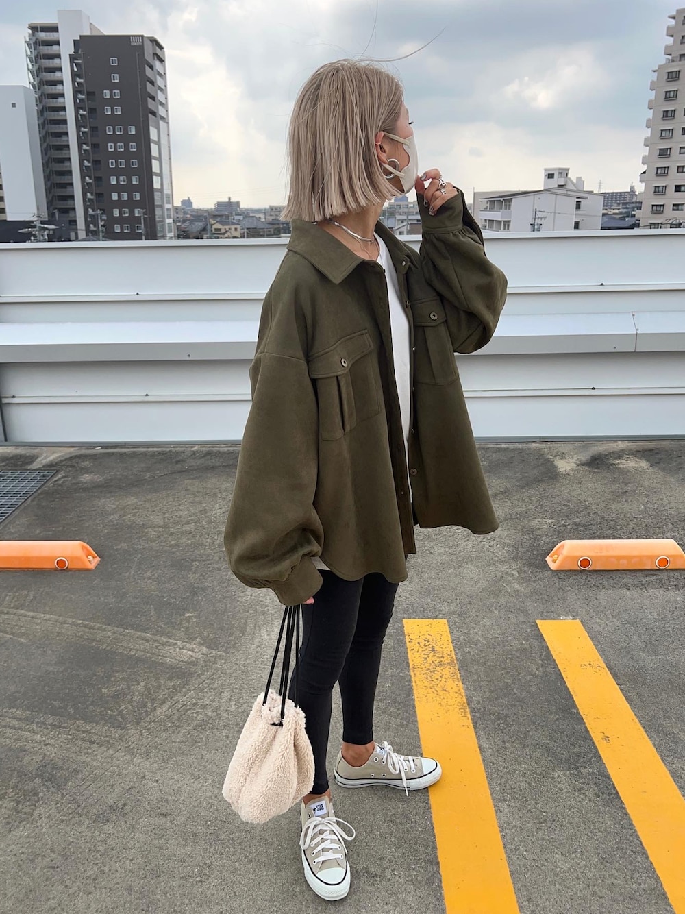 グリーン系のミリタリージャケット、ベージュ系のバッグを着用したレディースの秋コーディネートの1枚目の写真