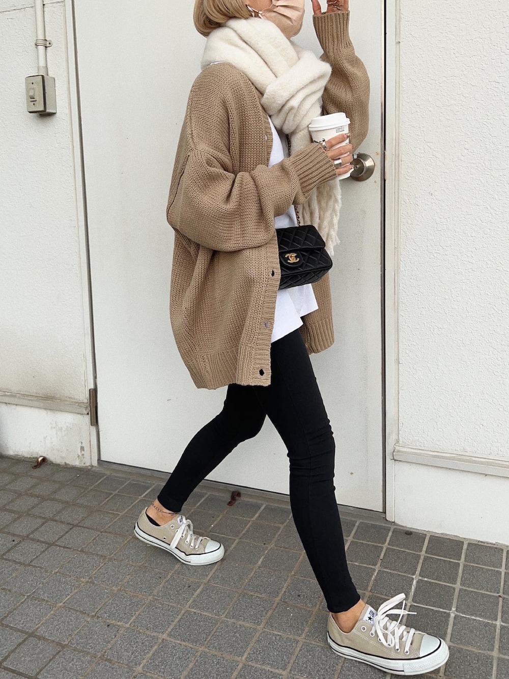 ベージュ系のカーディガン/ボレロ、ブラック系のショルダーバッグ、ブラック系のパンツを着用したレディースの冬コーディネートの1枚目の写真