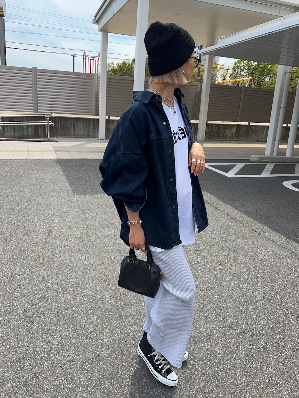 ホワイト系のTシャツ/カットソー、ブラック系のボストンバッグ、グレー系のスカートを着用したレディースの春コーディネートの1枚目の写真