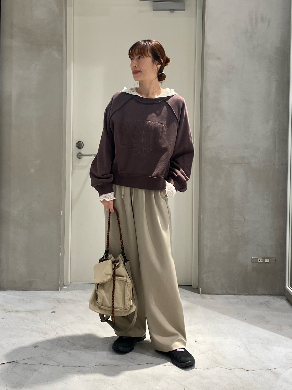 ブラウン系のスウェット、ホワイト系のTシャツ/カットソー、ベージュ系のスラックスを着用したレディースの秋コーディネートの1枚目の写真