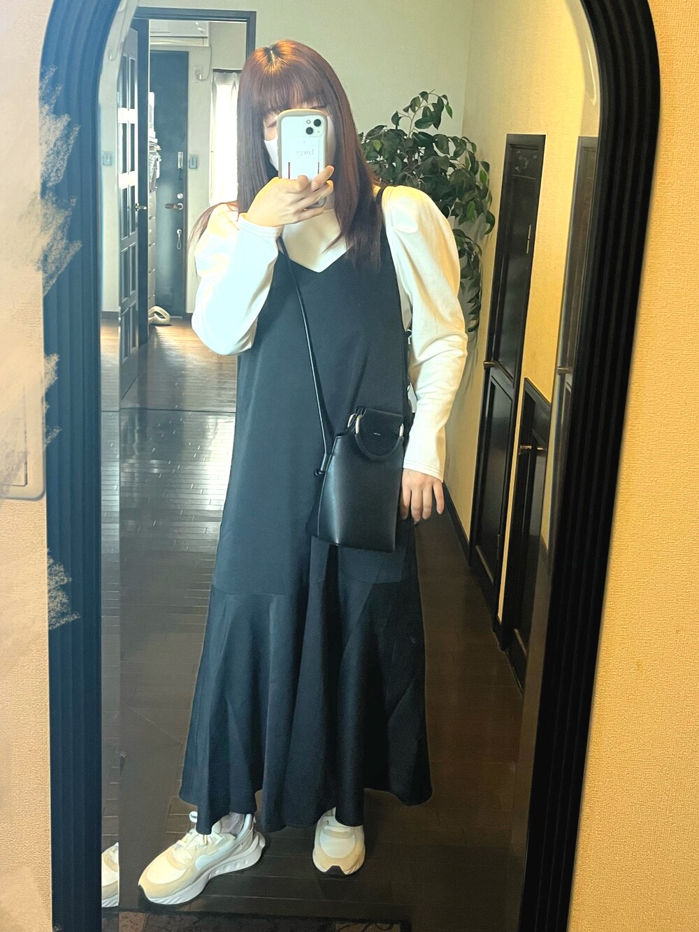 ブラック系のワンピース、ホワイト系のTシャツ/カットソー、ベージュ系のスニーカーを着用したレディースの春コーディネートの1枚目の写真
