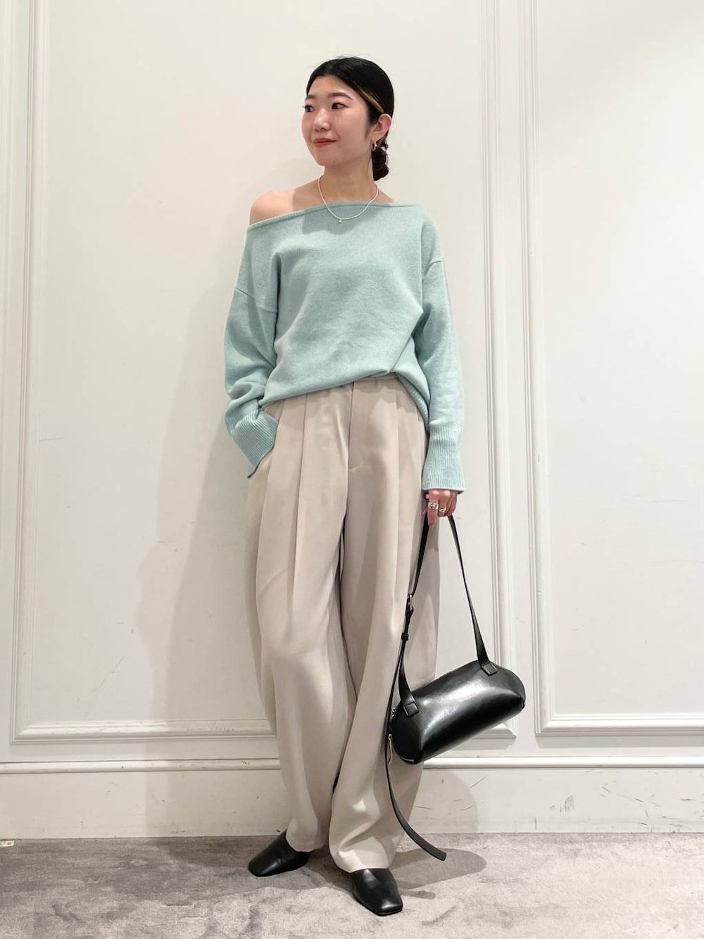 グリーン系のニット/セーター、ベージュ系のその他パンツ、ブラック系のショルダーバッグを着用したレディースの冬コーディネートの1枚目の写真