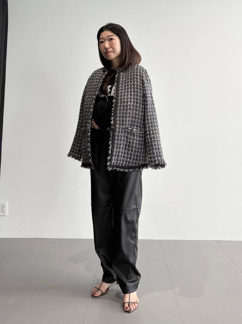 ベージュ系のサンダル、ブラック系のその他パンツ、ブラック系のその他アウターを着用したレディースの秋コーディネートの1枚目の写真