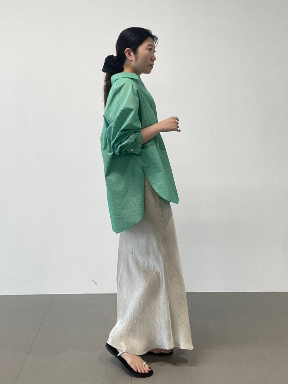 ブラック系のサンダル、ゴールド系のスカート、グリーン系のシャツ/ブラウスを着用したレディースの夏コーディネートの1枚目の写真