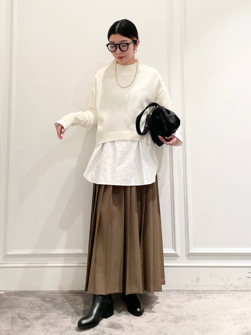 ブラック系のショルダーバッグ、ブラウン系のスカート、ホワイト系のシャツ/ブラウスを着用したレディースの冬コーディネートの1枚目の写真