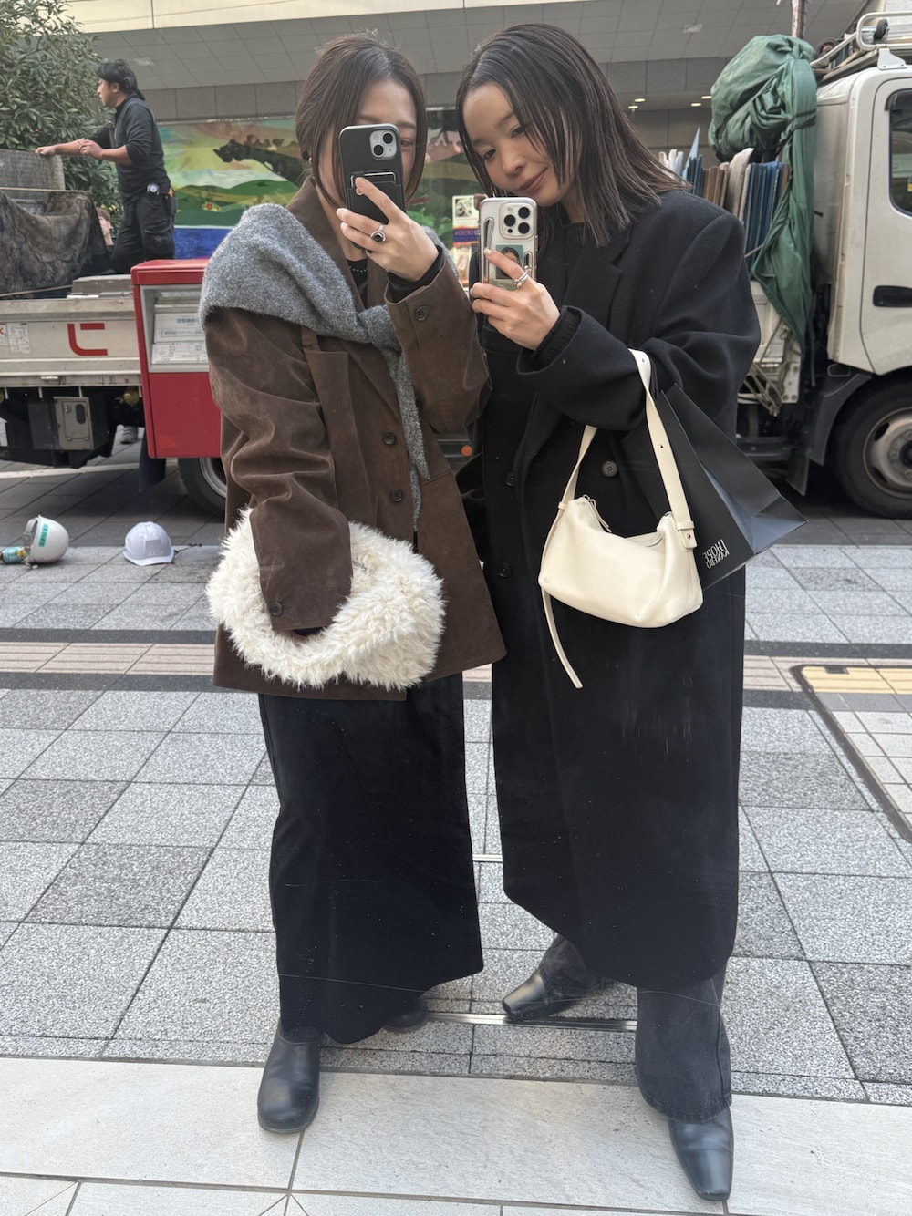 ブラック系のステンカラーコート、ブラック系のニット/セーター、ブラック系のデニムパンツを着用したレディースの秋コーディネートの1枚目の写真