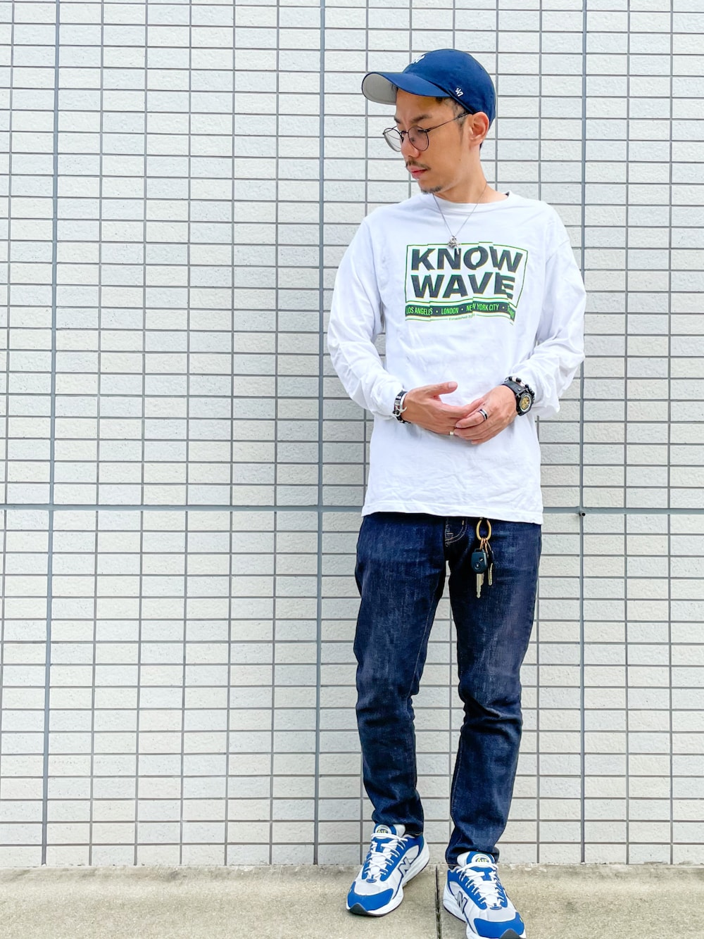 ブルー系のスニーカー、ブルー系のデニムパンツ、ホワイト系のTシャツ/カットソーを着用したメンズの秋コーディネートの1枚目の写真