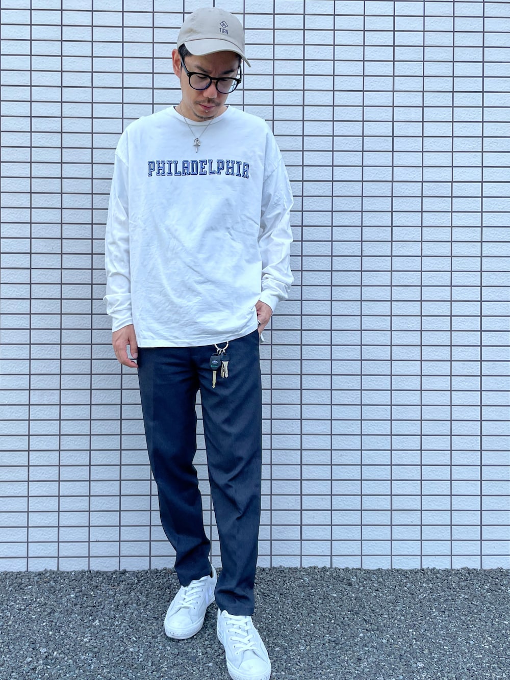 ホワイト系のスニーカー、ホワイト系のTシャツ/カットソー、ブラック系のメガネを着用したメンズの春コーディネートの1枚目の写真