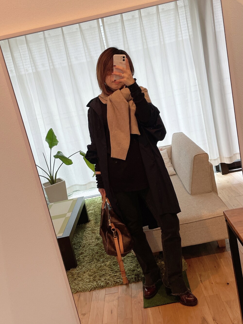 ブラウン系のブーツ、ブラック系のデニムパンツ、ブラウン系のボストンバッグを着用したレディースの秋コーディネートの1枚目の写真