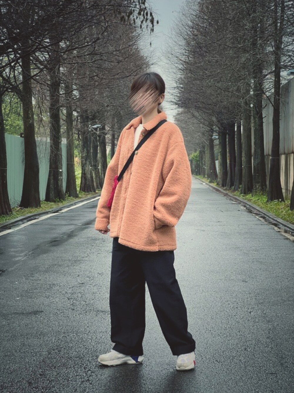 ブラック系のパンツ、オレンジ系のその他アウター、レッド系のボディバッグ/ウエストポーチを着用したレディースの冬コーディネートの1枚目の写真