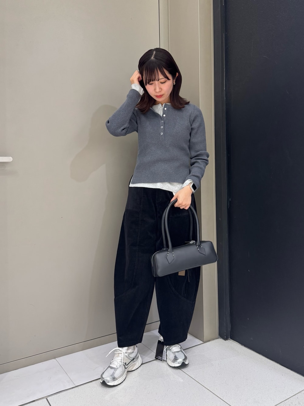 グレー系のニット/セーター、ブラック系のハンドバッグ、ブラック系のその他パンツを着用したレディースの秋コーディネートの1枚目の写真