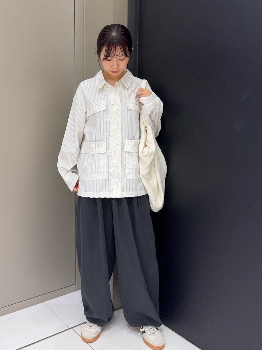グレー系のその他パンツ、ホワイト系のトートバッグ、ホワイト系のシャツ/ブラウスを着用したレディースの秋コーディネートの1枚目の写真