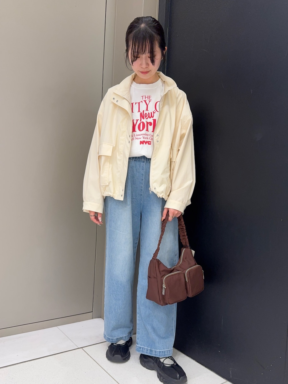 レッド系のTシャツ/カットソー、ホワイト系のブルゾン、ブルー系のデニムパンツを着用したレディースの春コーディネートの1枚目の写真