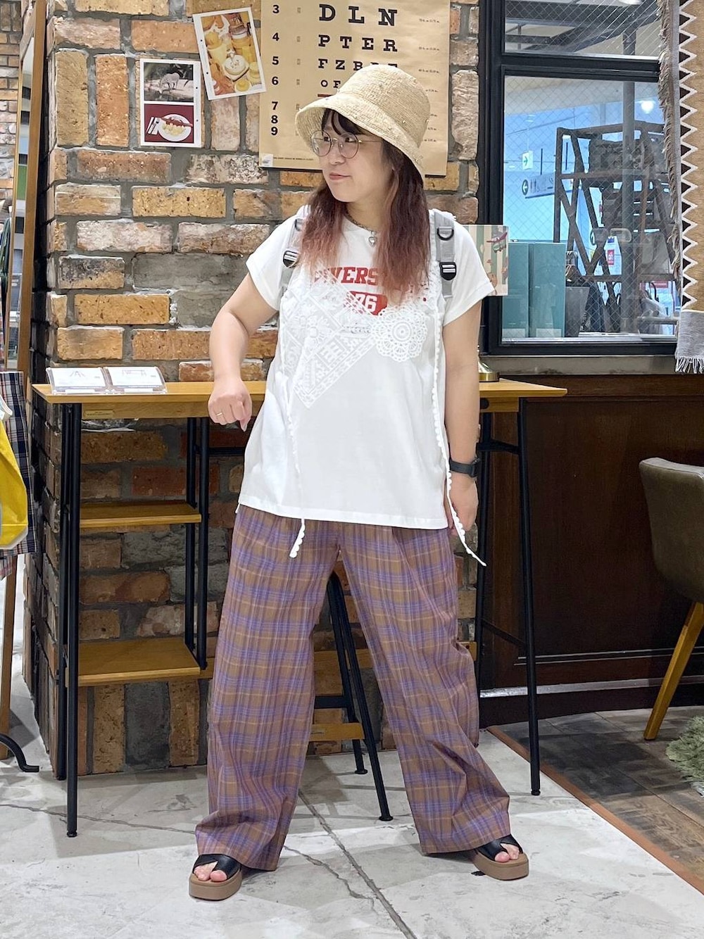 ブラック系のサンダル、ホワイト系のTシャツ/カットソー、グレー系のバックパック/リュックを着用したレディースの夏コーディネートの1枚目の写真
