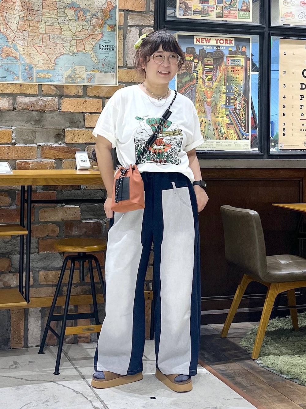 オレンジ系のショルダーバッグ、ブルー系のデニムパンツ、ブラウン系のサンダルを着用したレディースの夏コーディネートの1枚目の写真