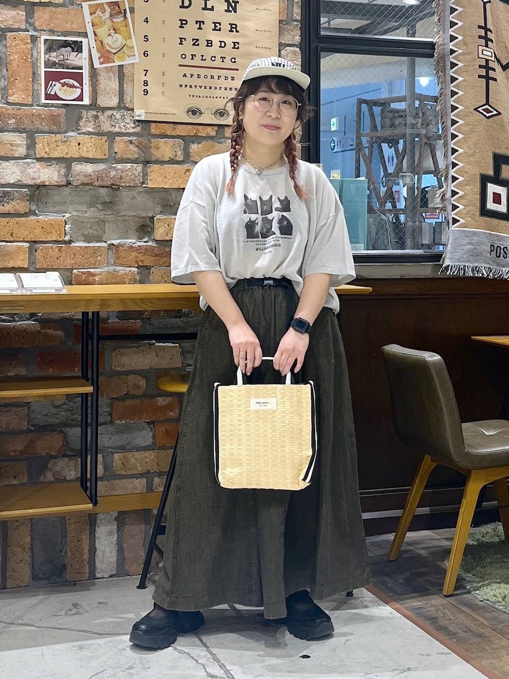 ブラウン系のスカート、ブラック系のスニーカー、ベージュ系のトートバッグを着用したレディースの春コーディネートの1枚目の写真