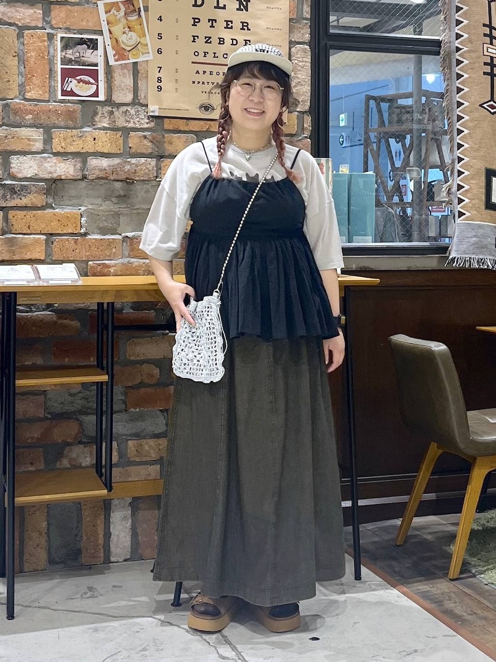 ブラウン系のスカート、ブラウン系のサンダル、グレー系のショルダーバッグを着用したレディースの春コーディネートの1枚目の写真