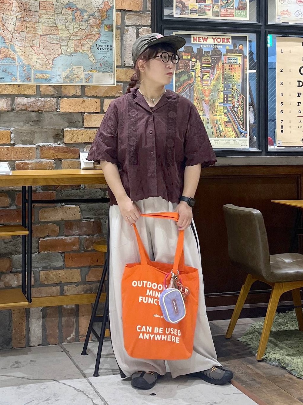 ブラウン系のその他パンツ、ブラウン系のシャツ/ブラウス、レッド系のトートバッグを着用したレディースの夏コーディネートの1枚目の写真