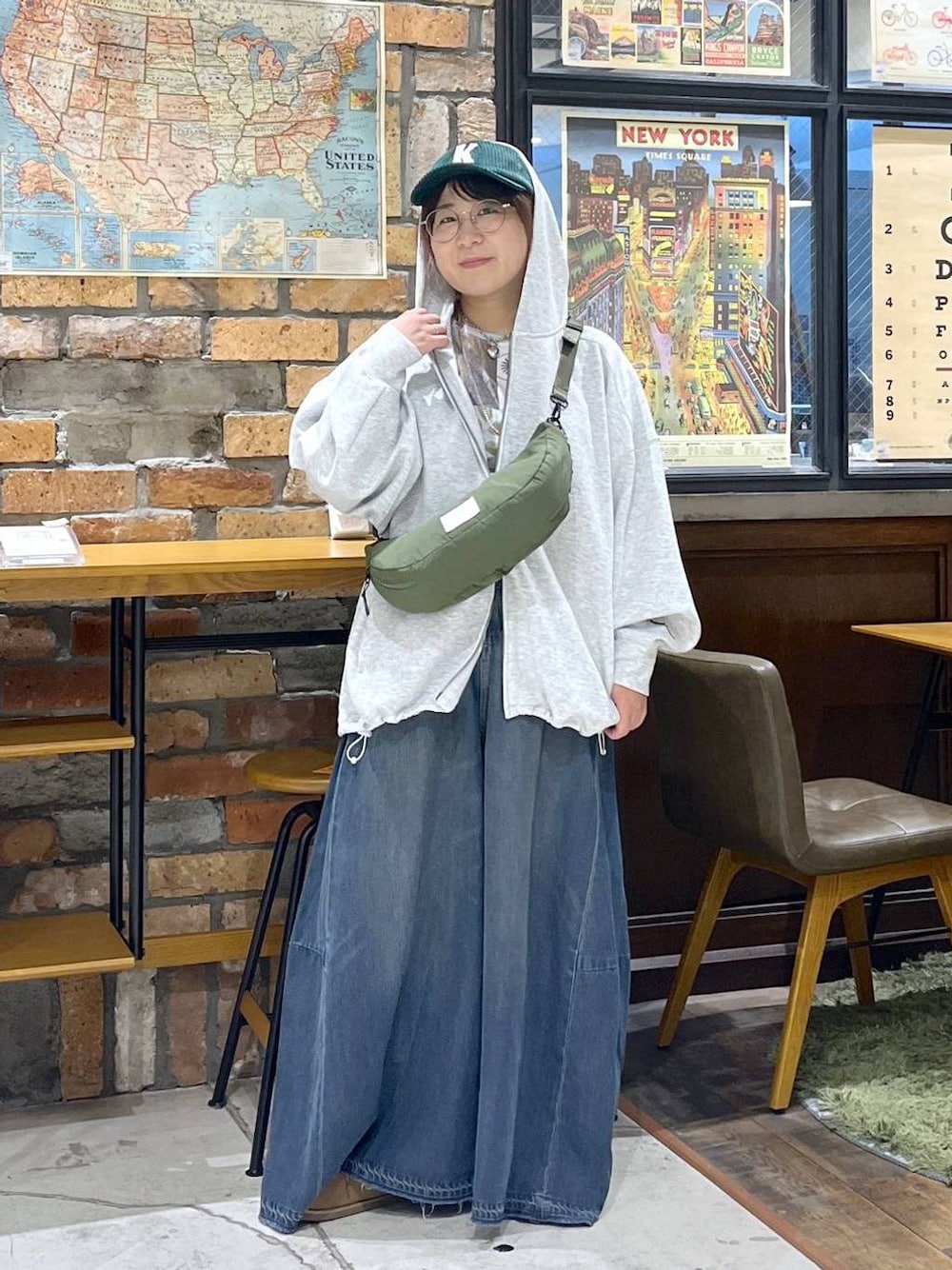 グレー系のパーカー、グリーン系のショルダーバッグ、イエロー系のモカシン/デッキシューズを着用したレディースの秋コーディネートの1枚目の写真