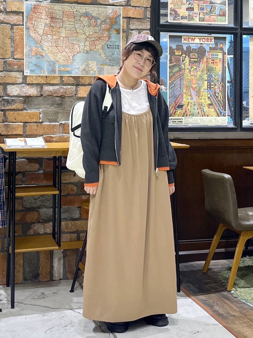 ホワイト系のTシャツ/カットソー、ベージュ系のワンピース、ベージュ系のバックパック/リュックを着用したレディースの秋コーディネートの1枚目の写真